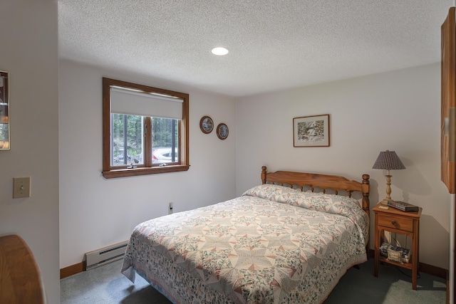 bedroom featuring carpet flooring, a textured ceiling, and a baseboard heating unit