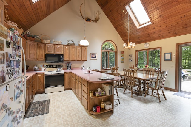 kitchen featuring kitchen peninsula, pendant lighting, a skylight, and white appliances