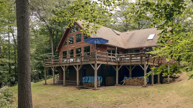 rear view of property featuring a deck and a yard