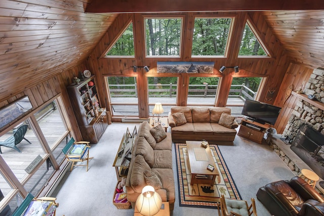 unfurnished living room with a stone fireplace, wooden walls, carpet, and high vaulted ceiling