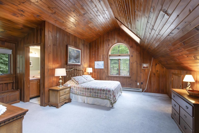 bedroom with light colored carpet, baseboard heating, connected bathroom, and vaulted ceiling