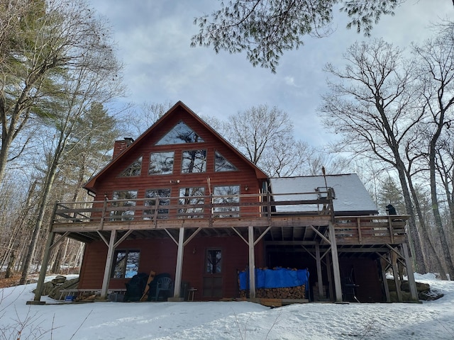 snow covered house featuring a wooden deck