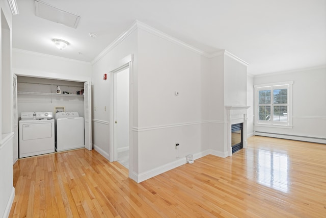 laundry room featuring independent washer and dryer, a baseboard radiator, crown molding, and light wood-type flooring