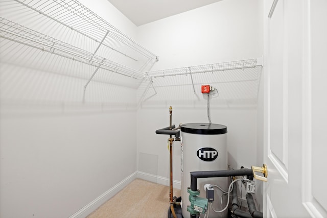 walk in closet with water heater and carpet