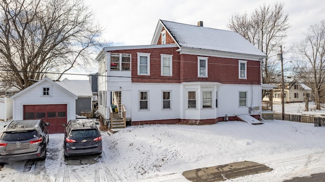 view of front of home featuring a garage and an outbuilding