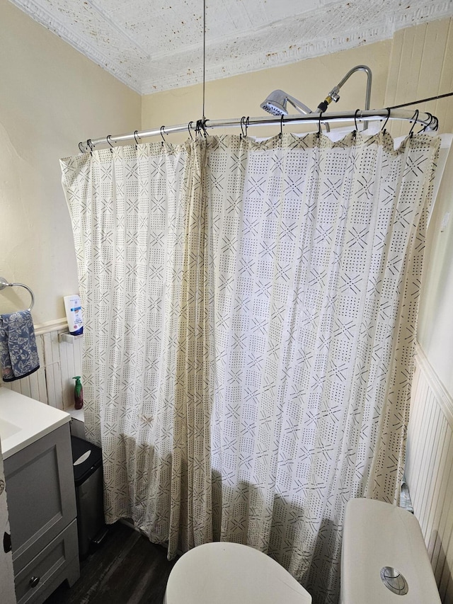 bathroom featuring wood walls, vanity, shower / tub combo with curtain, and hardwood / wood-style floors