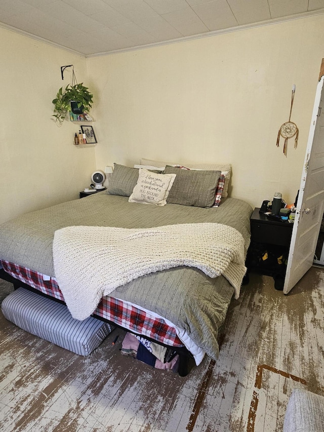 bedroom with ornamental molding and hardwood / wood-style floors