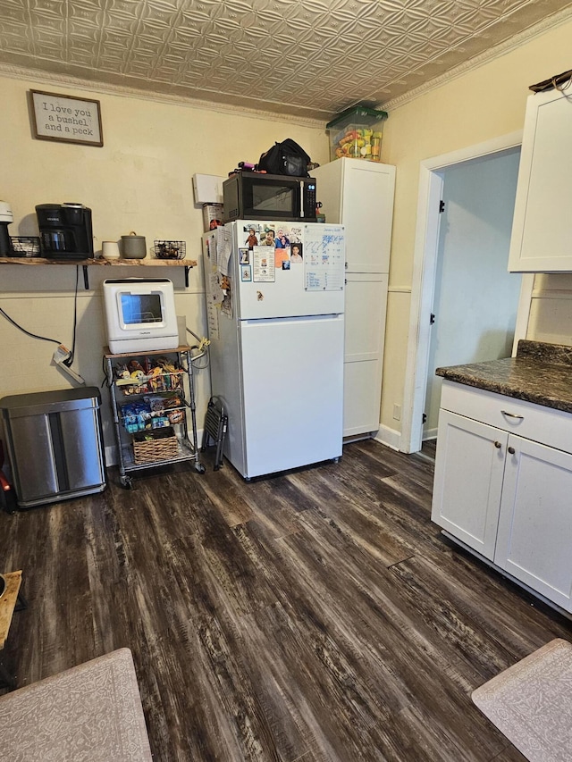 kitchen with white cabinets, white refrigerator, and dark hardwood / wood-style flooring