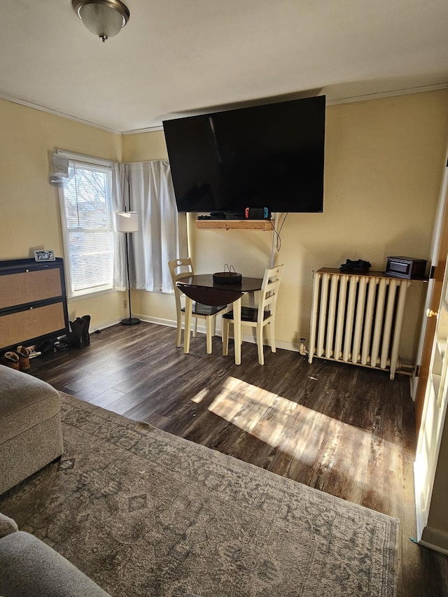 bedroom with ornamental molding, dark wood-type flooring, and radiator