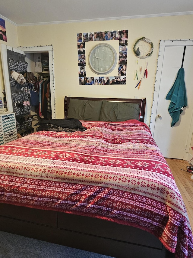 bedroom featuring a closet, crown molding, and hardwood / wood-style floors