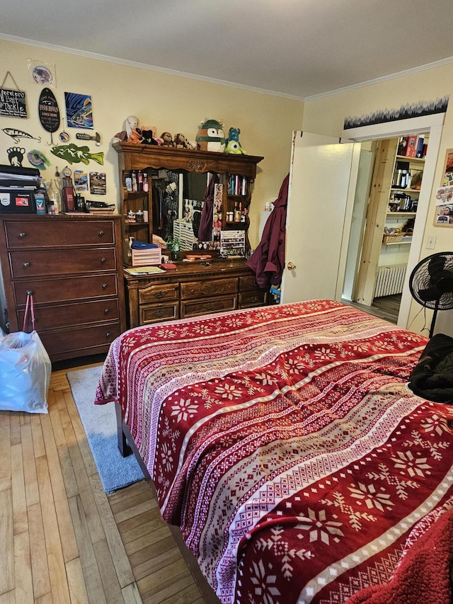 bedroom featuring wood-type flooring and ornamental molding