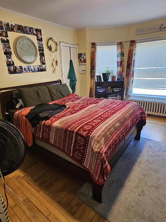 bedroom featuring radiator heating unit, hardwood / wood-style flooring, and crown molding