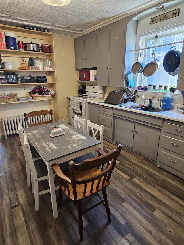 kitchen with white electric range, gray cabinetry, hanging light fixtures, and dark wood-type flooring