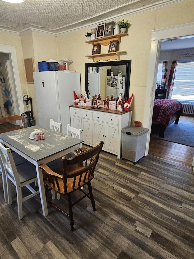 dining area featuring a textured ceiling, crown molding, and dark hardwood / wood-style flooring