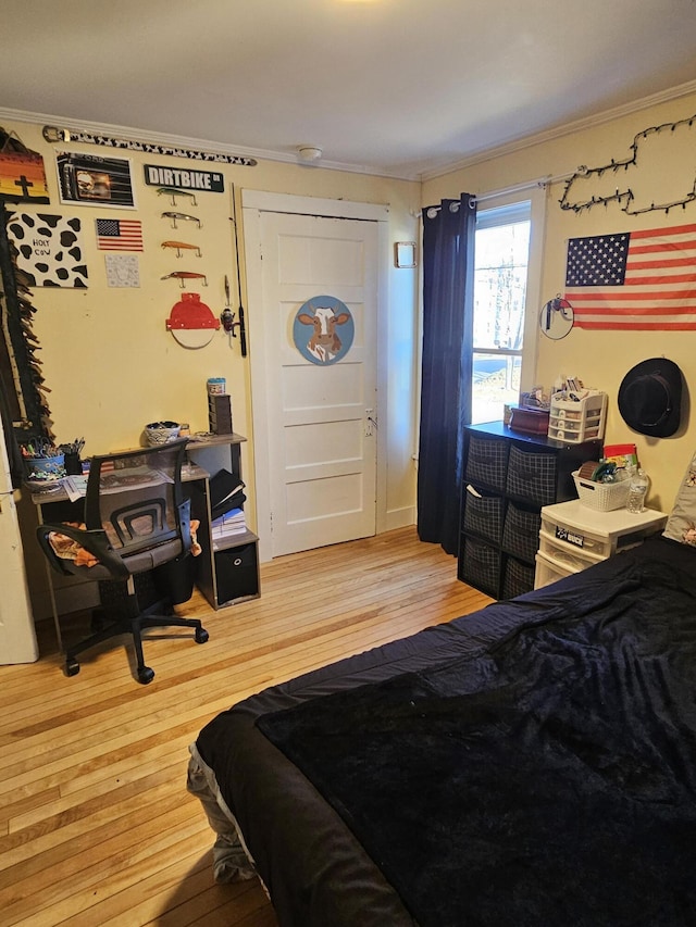 bedroom featuring ornamental molding and light wood-type flooring