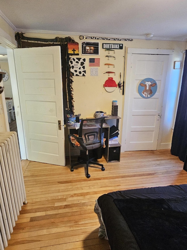 bedroom with ornamental molding and light wood-type flooring