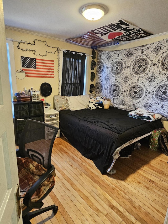 bedroom with hardwood / wood-style flooring and ornamental molding