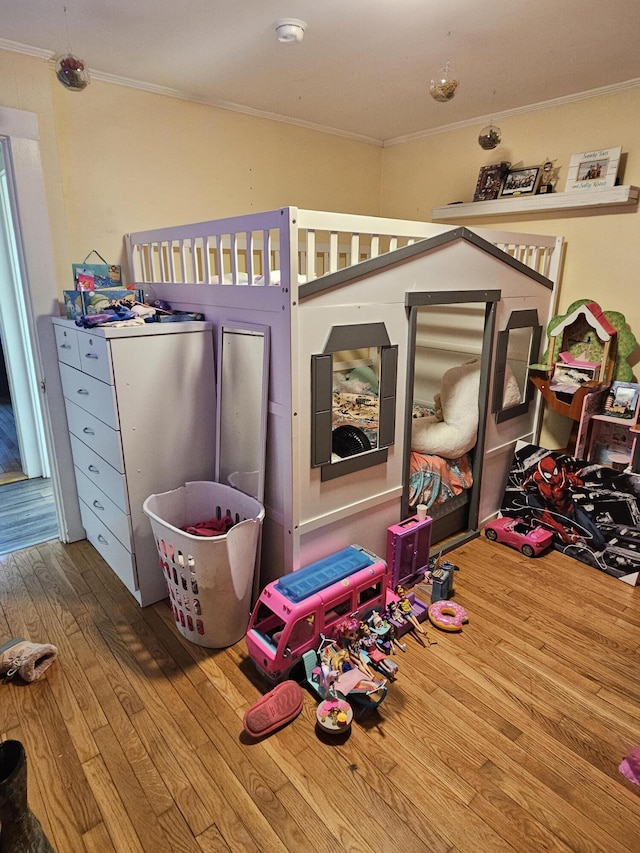 bedroom featuring ornamental molding and hardwood / wood-style flooring