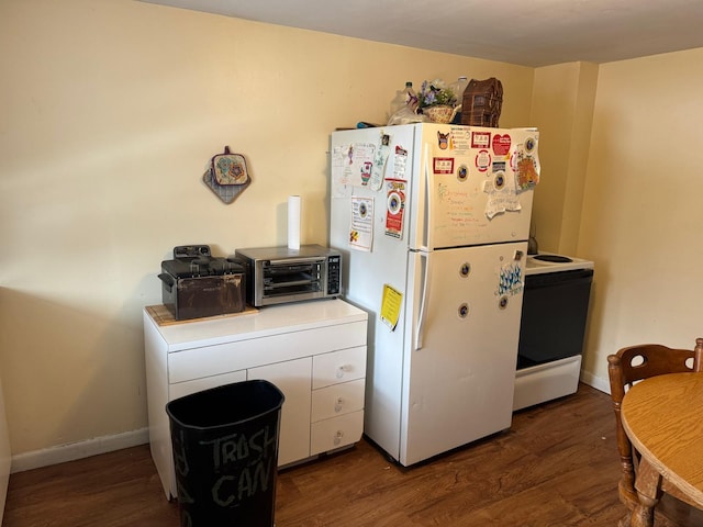 10 Russ St, Caribou, ME 04736 - kitchen featuring dark wood finished floors, white appliances, baseboards, and a toaster