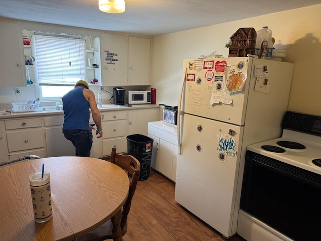 10 Russ St, Caribou, ME 04736 - kitchen with white cabinetry, wood finished floors, light countertops, and white appliances