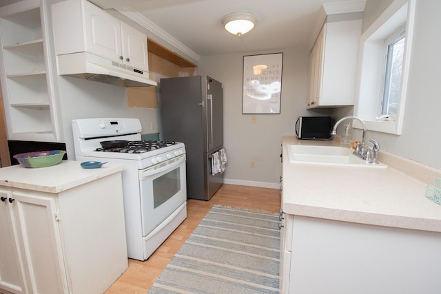 kitchen featuring white cabinets, sink, white range with gas cooktop, light wood-type flooring, and stainless steel refrigerator