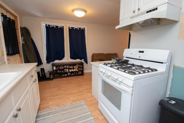 kitchen featuring white gas range, white cabinetry, and light hardwood / wood-style floors