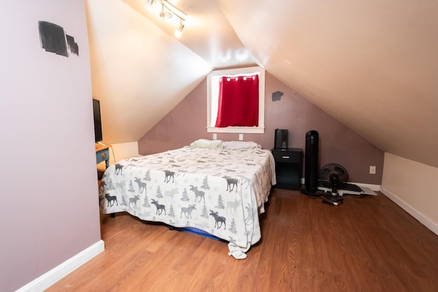 bedroom with hardwood / wood-style floors and lofted ceiling