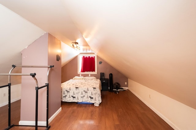 unfurnished bedroom featuring dark wood-type flooring and vaulted ceiling