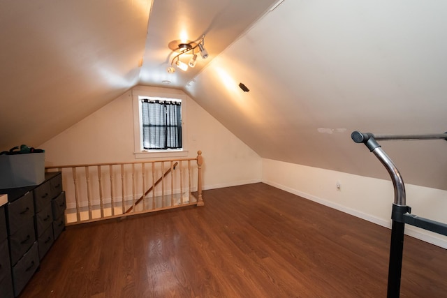 additional living space featuring lofted ceiling and dark wood-type flooring