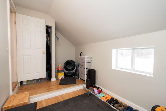 exercise room featuring hardwood / wood-style floors and vaulted ceiling