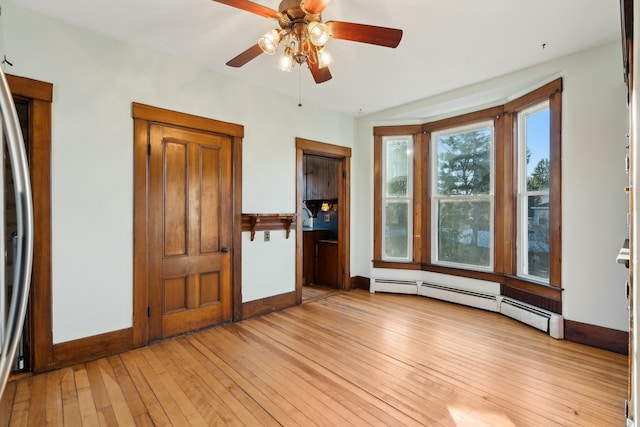 interior space with ceiling fan, baseboard heating, and light hardwood / wood-style flooring