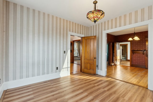 unfurnished bedroom with hardwood / wood-style flooring and a chandelier