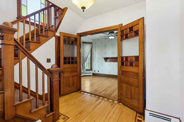 entryway featuring ceiling fan, plenty of natural light, wood-type flooring, and a baseboard heating unit