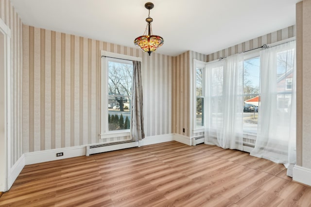 empty room featuring wood-type flooring and baseboard heating