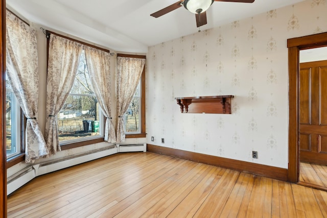 spare room featuring hardwood / wood-style floors, baseboard heating, and ceiling fan