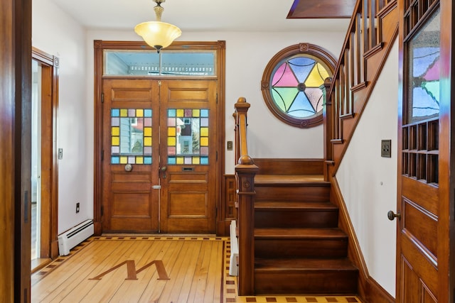 foyer featuring baseboard heating, french doors, and hardwood / wood-style flooring