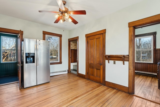 kitchen with stainless steel fridge with ice dispenser, light hardwood / wood-style flooring, ceiling fan, and a baseboard radiator