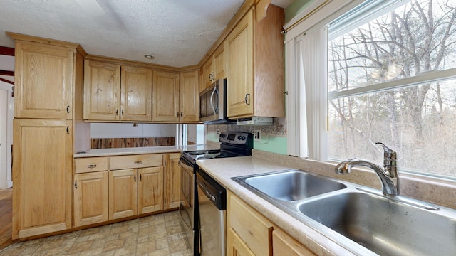 kitchen featuring stainless steel appliances, a textured ceiling, and sink