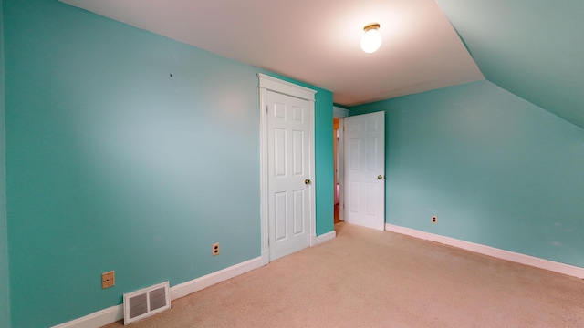 additional living space with vaulted ceiling and light carpet