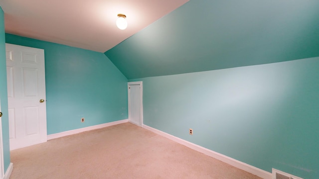 additional living space featuring lofted ceiling and carpet flooring