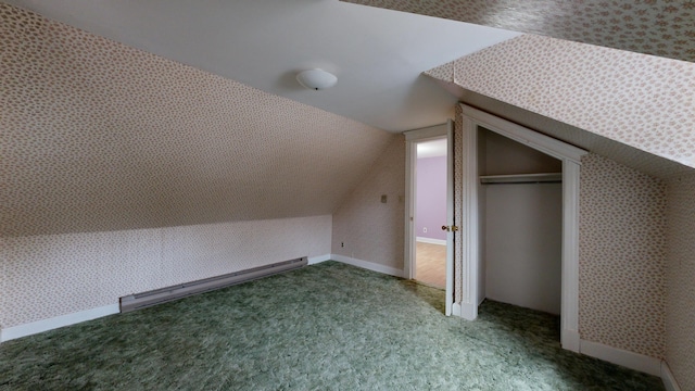 additional living space featuring vaulted ceiling, a baseboard radiator, and carpet