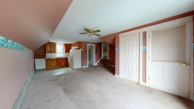 unfurnished living room with lofted ceiling, light colored carpet, and ceiling fan