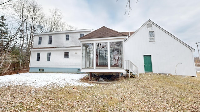 rear view of property with a lawn and a sunroom