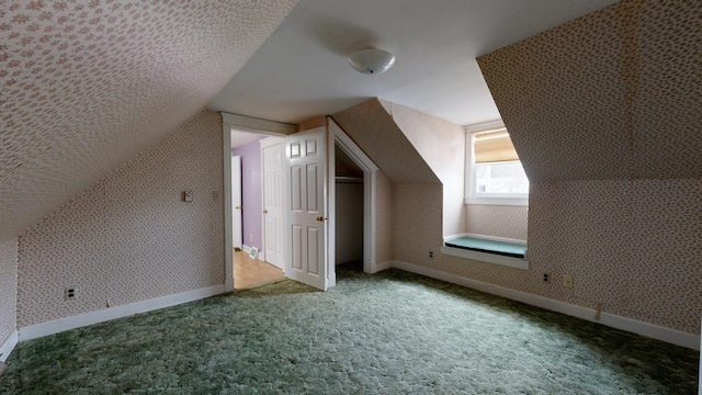 additional living space with vaulted ceiling and carpet flooring