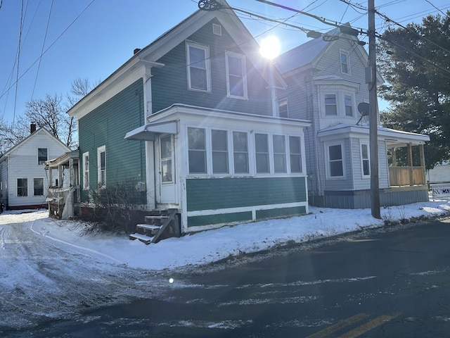 view of snowy exterior with a sunroom