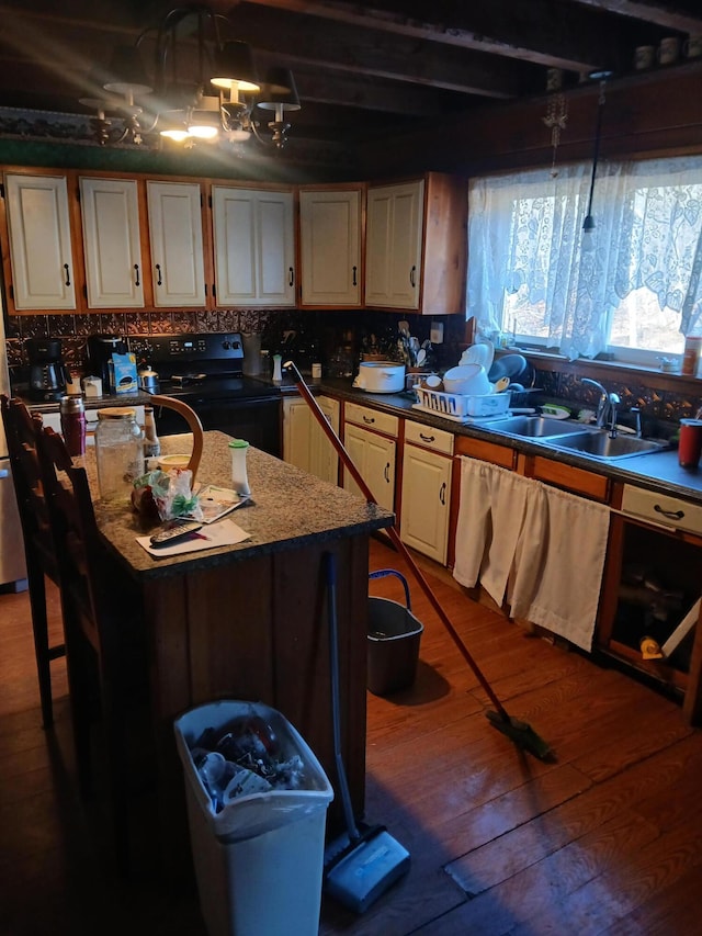 kitchen featuring a center island with sink, sink, light stone countertops, black / electric stove, and dark hardwood / wood-style flooring