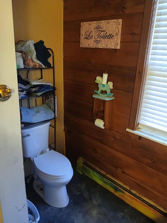 bathroom featuring wood walls and toilet