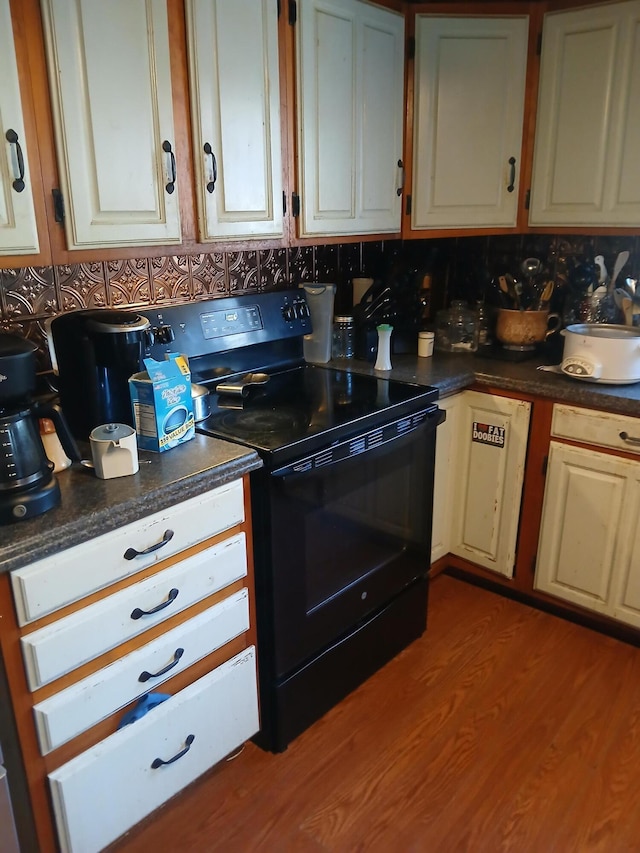 kitchen with decorative backsplash, light wood-type flooring, and black range with electric stovetop