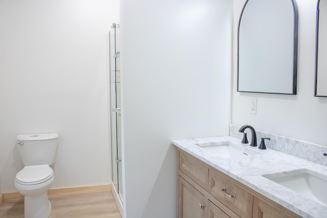 284 Flanders Pond Rd, Sullivan, ME 04664 - full bathroom with double vanity, a shower with shower door, and wood finished floors