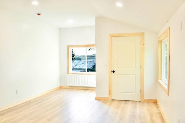 284 Flanders Pond Rd, Sullivan, ME 04664 - spare room with radiator heating unit, light wood-style flooring, vaulted ceiling, and recessed lighting